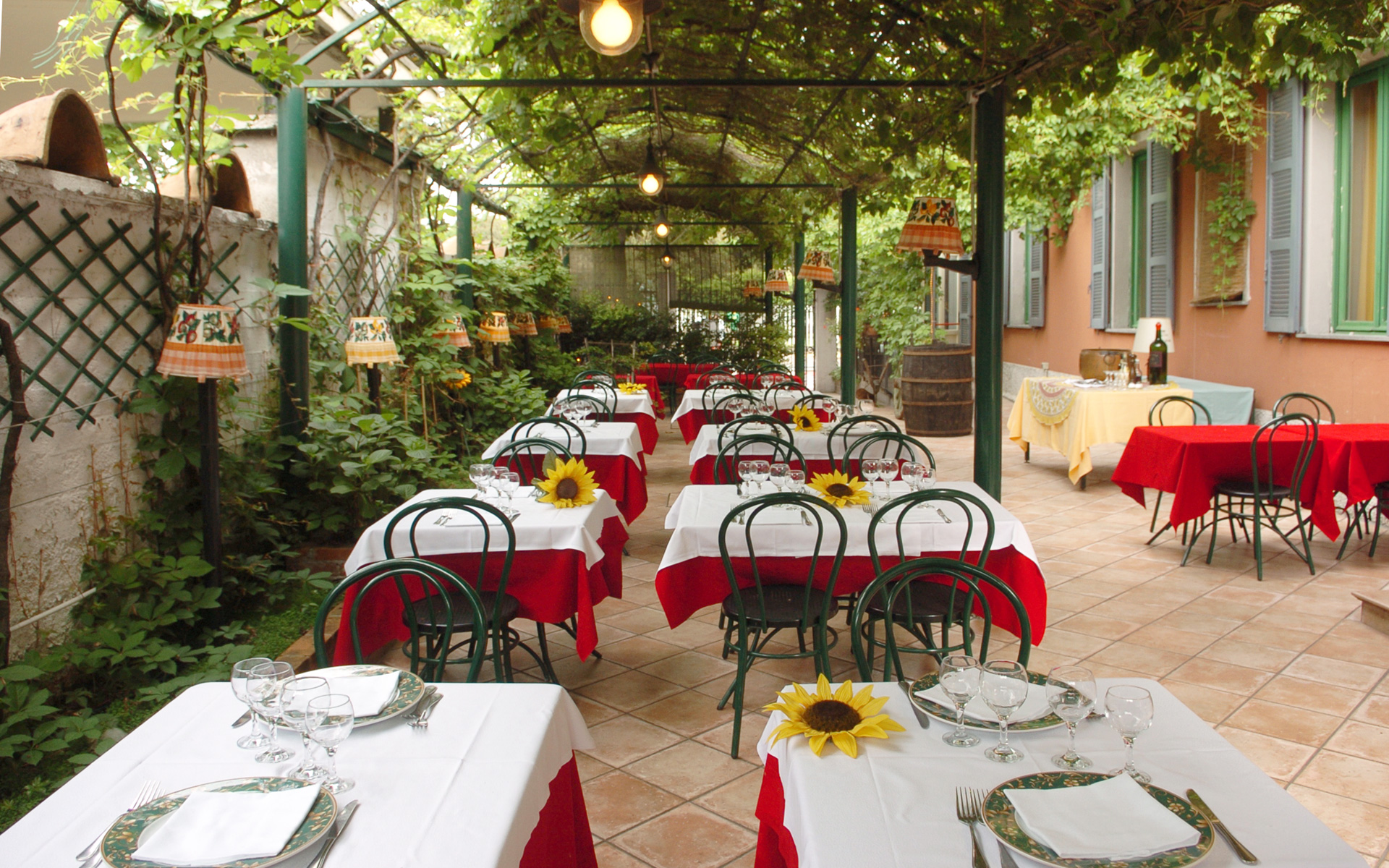 Il giardino estivo del Ristorante Pentola d'Oro con pergolato e tavoli all'aperto
